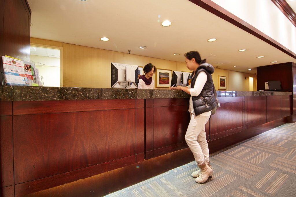 two people standing at the front desk